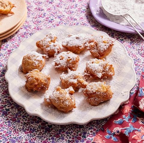 apple fritters on purple plate with powdered sugar