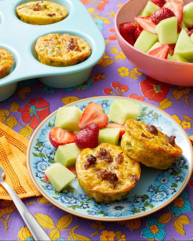 individual sausage and egg casseroles on plate with fruit salad