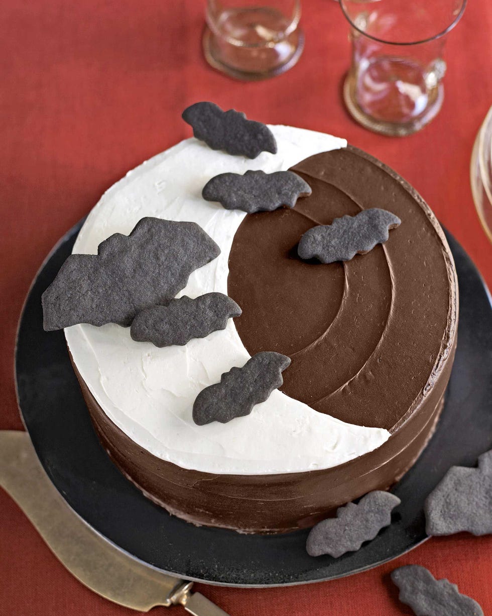 chocolate cake with moon shaped icing and bat cookies