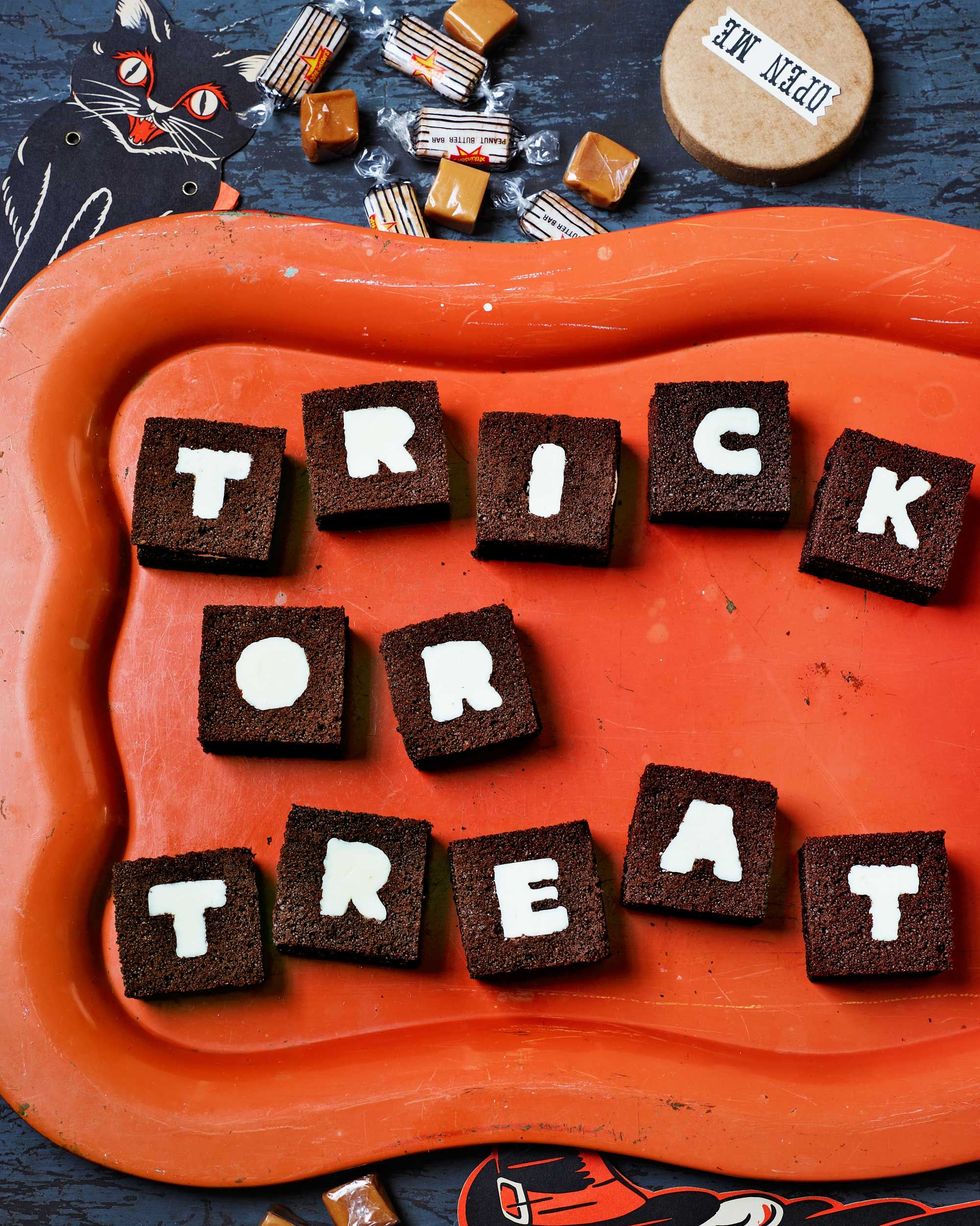12 small cake sandwiches with single letters on them spelling trick or treat