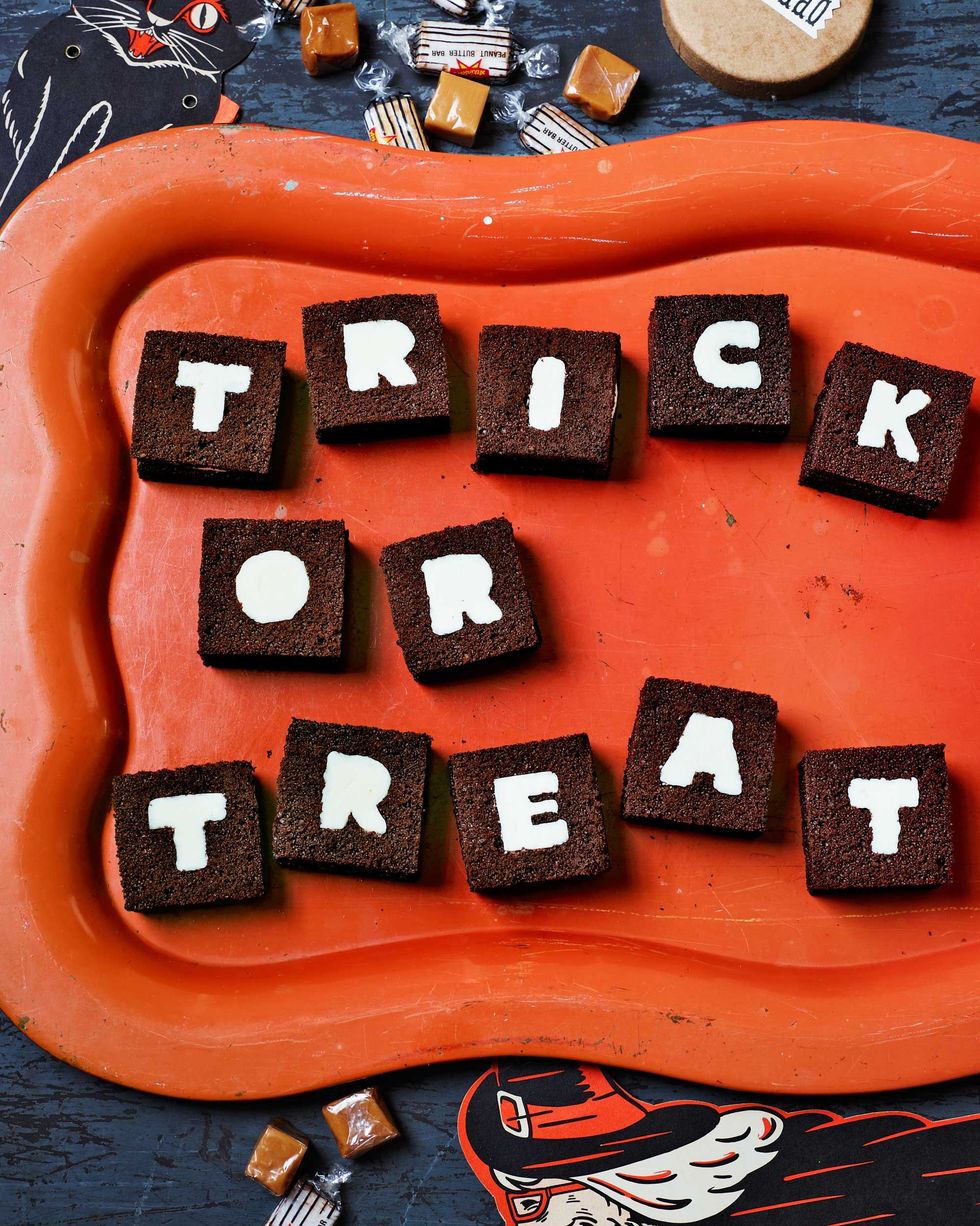 12 small cake sandwiches with single letters on them spelling trick or treat