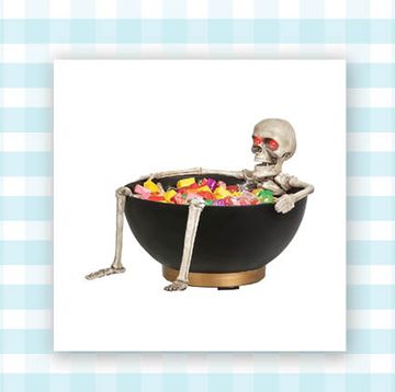skull bowl and black bowl with skeleton laying in it and candy inside