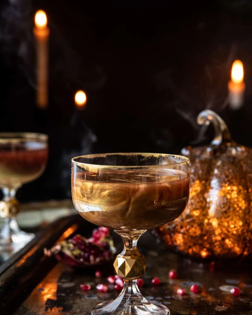 poisoned apple cocktail in a glass with edible gold glitter