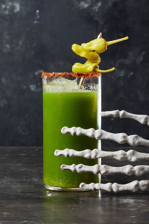 tomatillo bloody mary halloween cocktail with a skeleton hand reaching for it