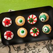 halloween cookies with eye balls on black plate green background