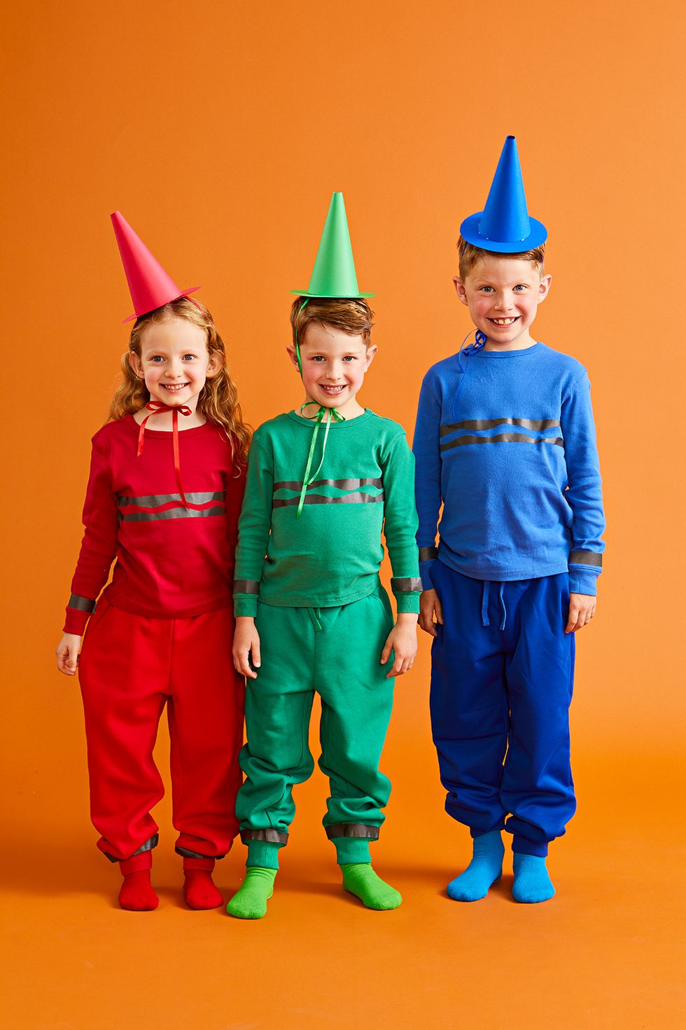three kids dressed as a red crayon, green crayon and blue crayons for halloween