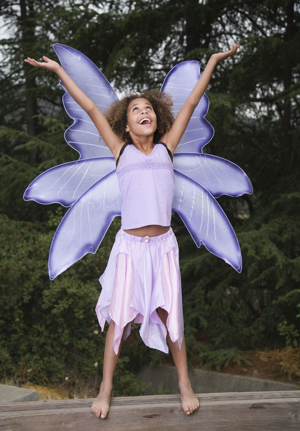 girl, about 11 or 12 years old, wearing fairy halloween costume for tweens with pale purple wings, tank top and flowy skirt