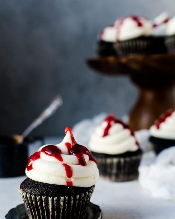 black velvet cupcakes with white frosting and raspberry jam