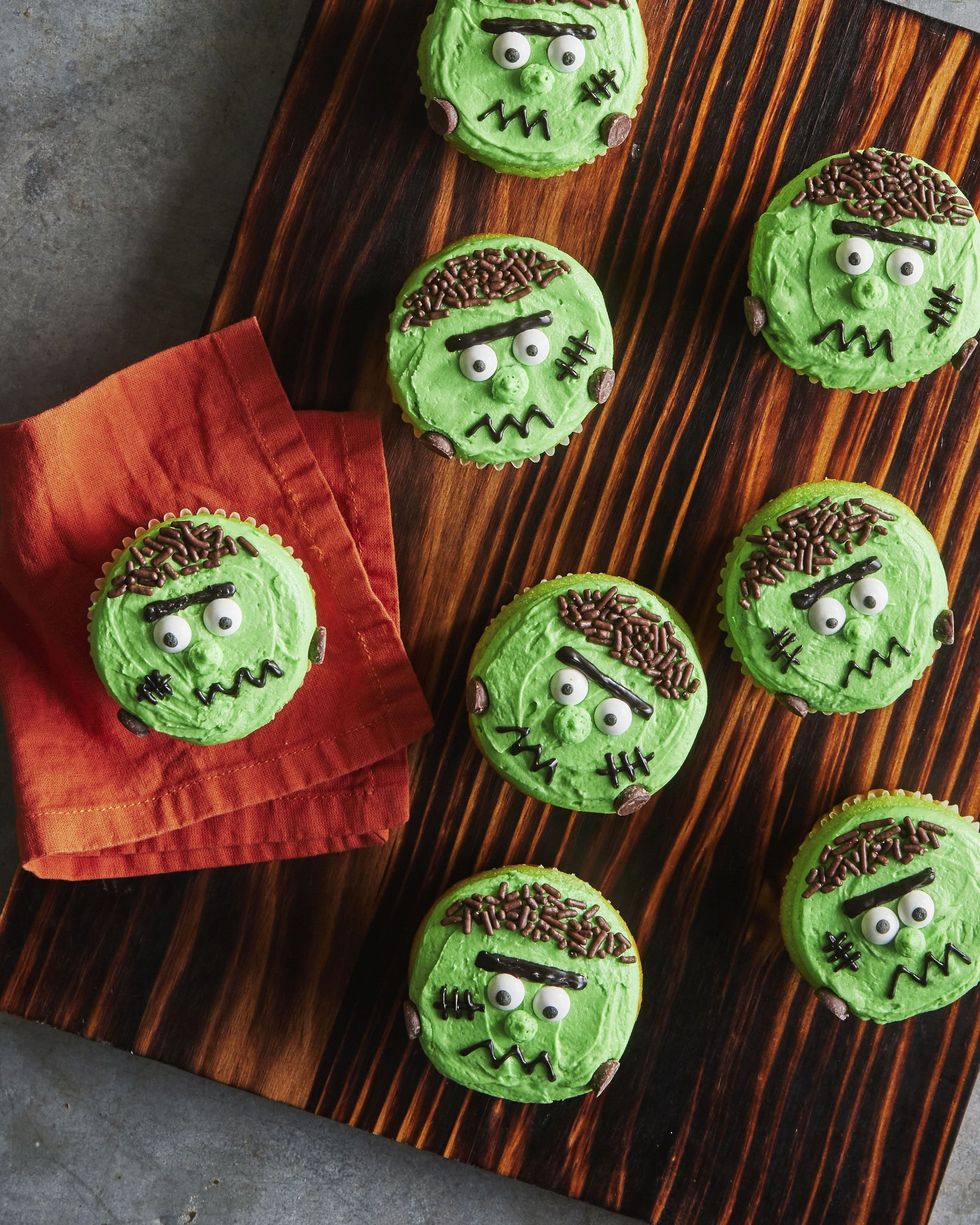 green frankenstein cupcakes on a wooden serving board