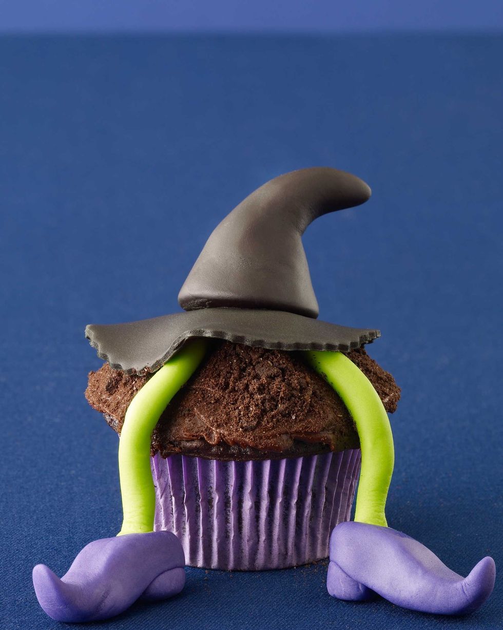 wicked witch chocolate cupcake with a fondant witch hat and fondant legs and shoes coming from underneath it