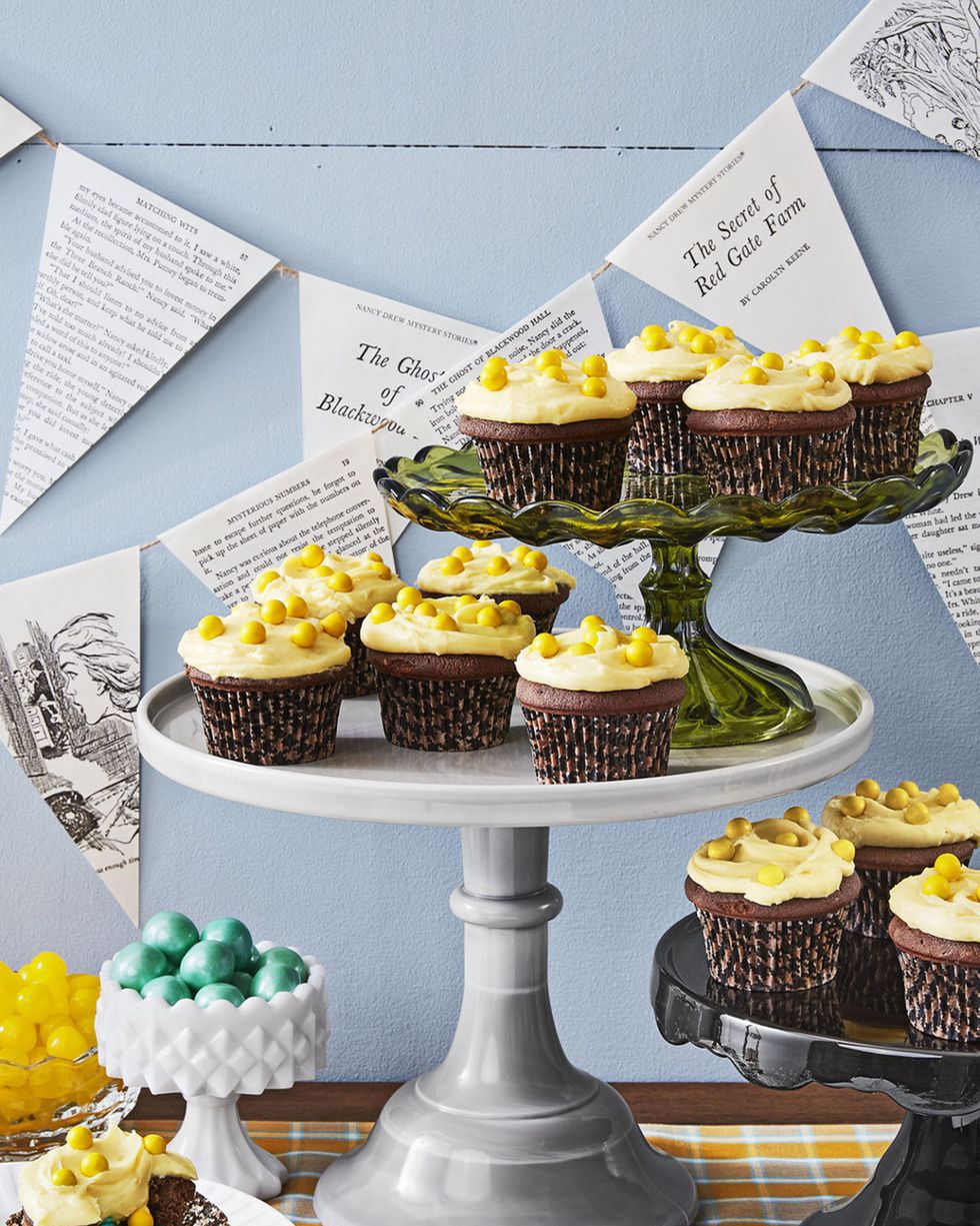 devils food cupcakes with yellow frosting and candies hiding in the middle