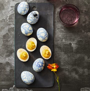 blue spider webbed deviled eggs on a black board blue spider webbed deviled eggs on a black board