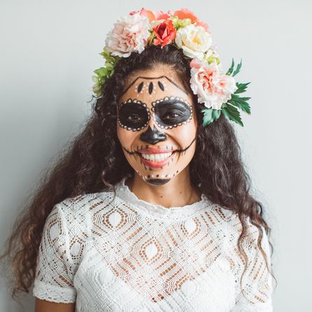 portrait of young woman with sugar skull creative make up for halloween