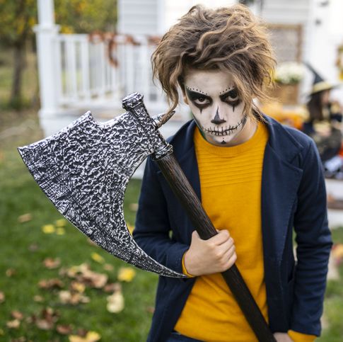 close up portrait of a boy with zombie make up and a halloween axe