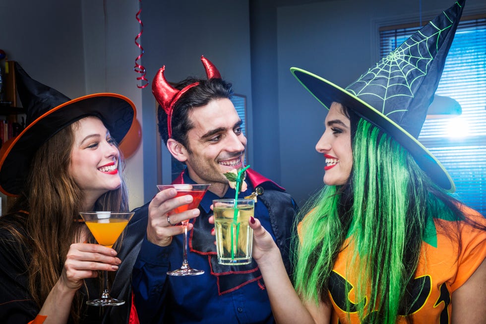 adults with cocktails in glasses and in costume