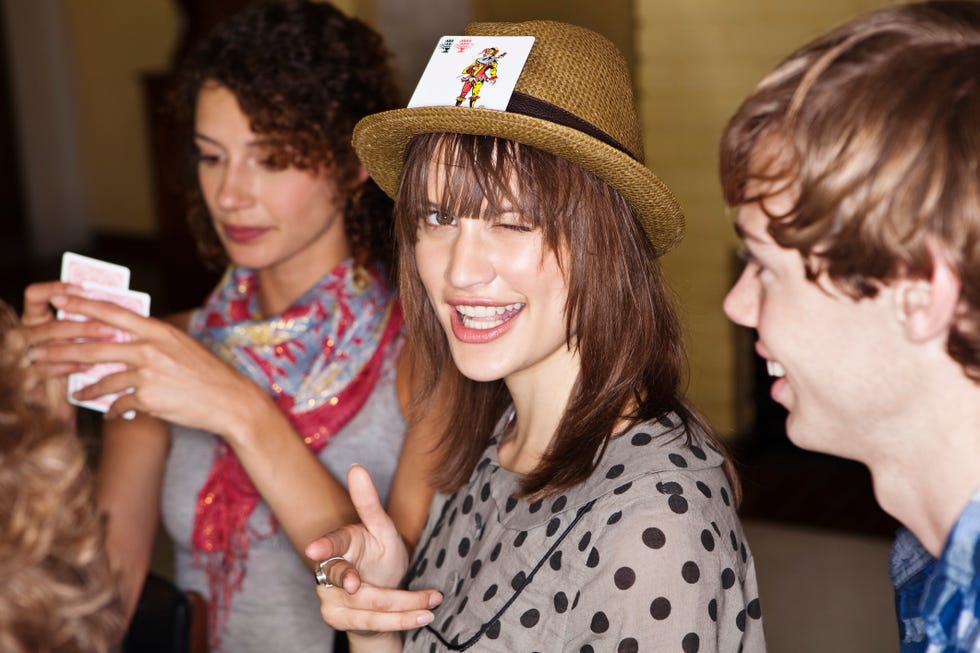 people playing cards while a woman winks