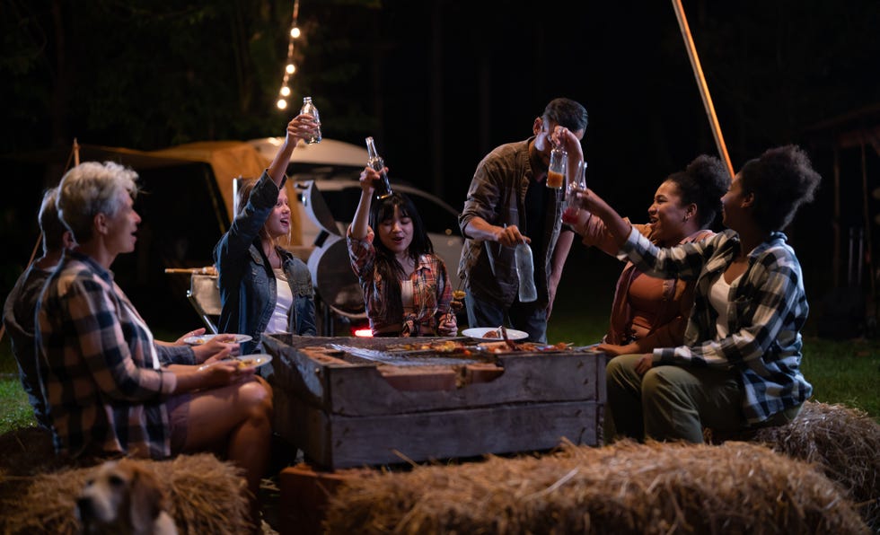 adults sitting by a bonfire outside