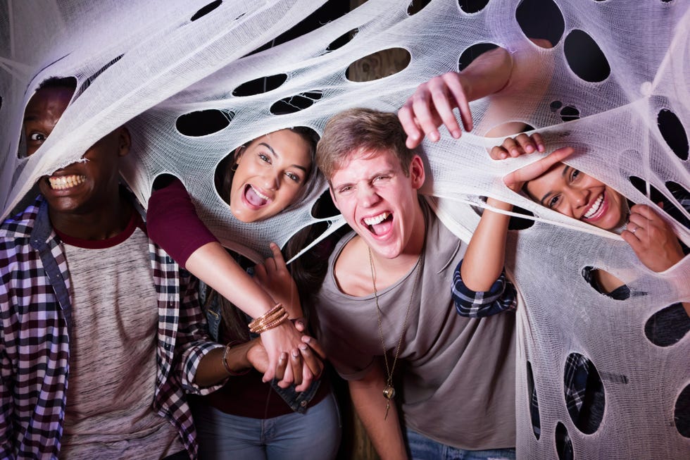 adults in a haunted house's fake spider web
