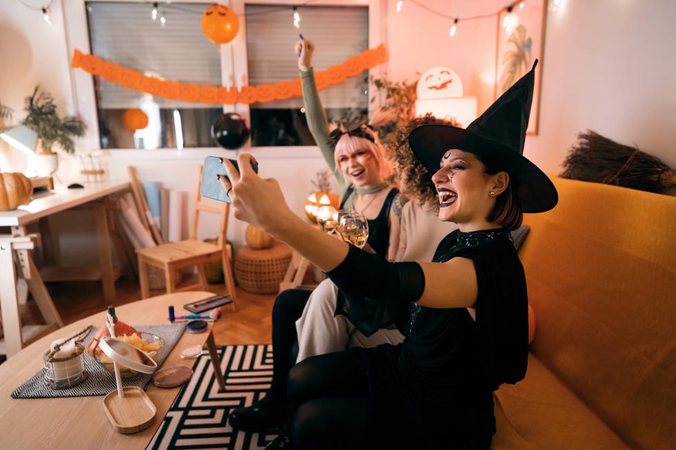 women posing in costume on the couch for a selfie