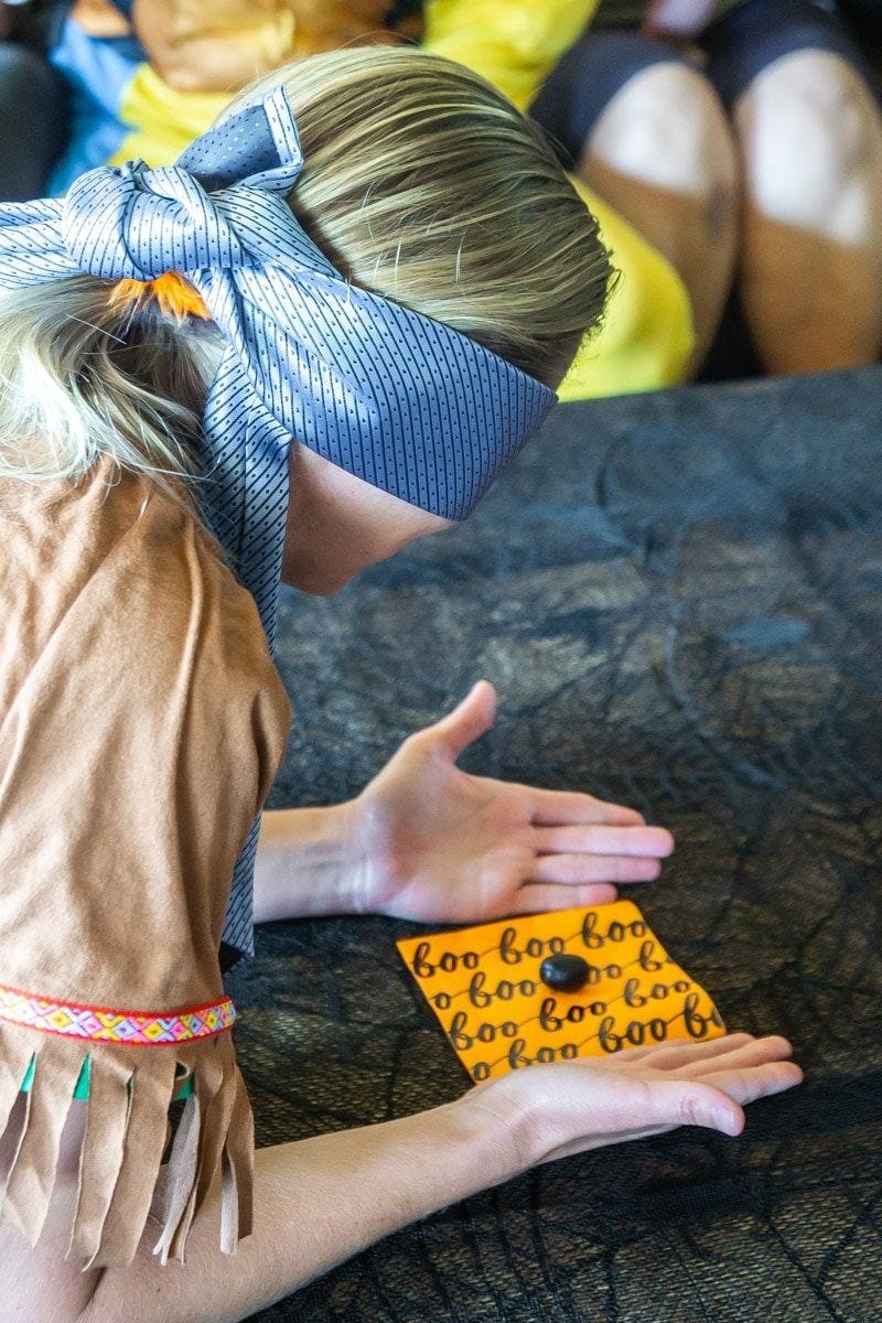 halloween games, woman blindfolded with one candy on a napkin