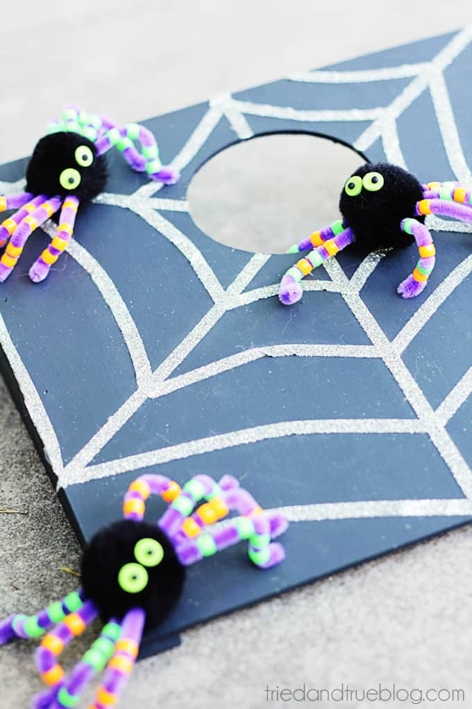 Cornhole set decorated with spider webs and pom-pom spiders