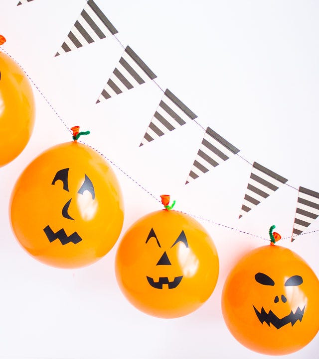a group of orange and black pumpkins with faces drawn on them