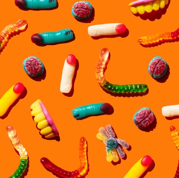 halloween jelly beans, fingershaped, brains, worm and vampire teeth on orange background