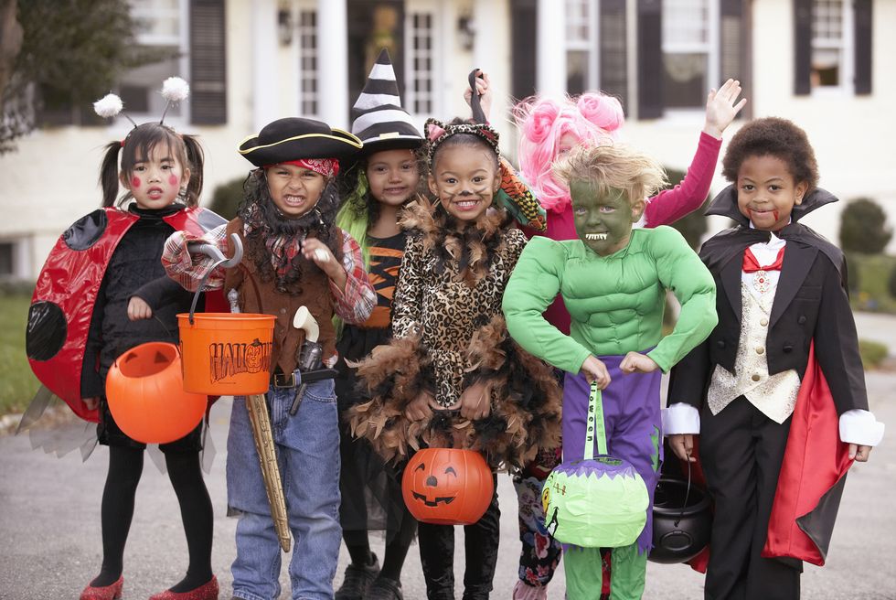 diverse group of children in fall costumes and halloween costumes
