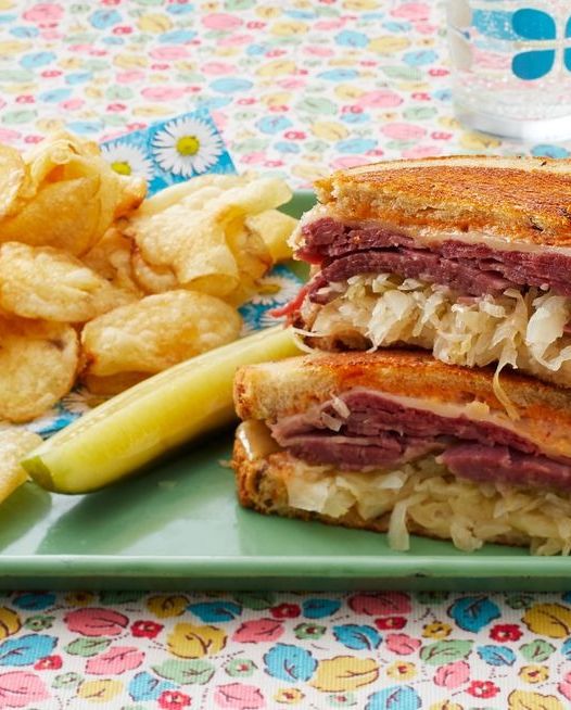 rueben sandwich with pickle and potato chips