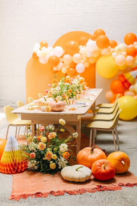 halloween party ideas, candy corn dinner table with pumpkins and orange and yellow balloons