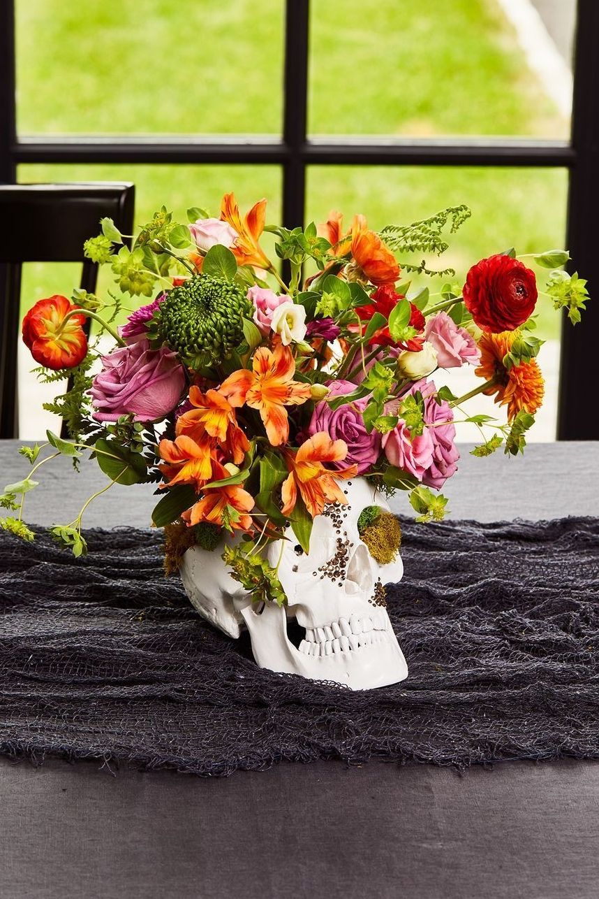 halloween party ideas, skull centerpiece on the table with flowers inside