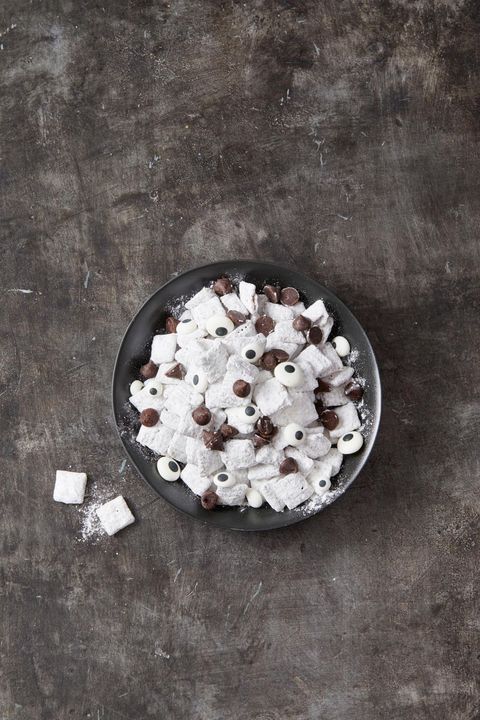 white powdered chex cereal snack mix with candy eyes and chocolate chips