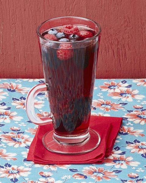 mulled pomegranate cherry juice in tall glass mug with berries