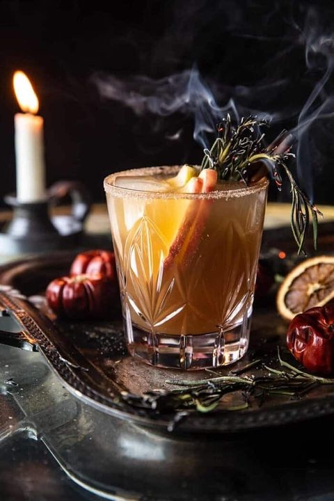 nightmare on bourbon street punch in cocktail glass with smoking herbs