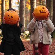 kids holding jack o lanterns in front of their faces