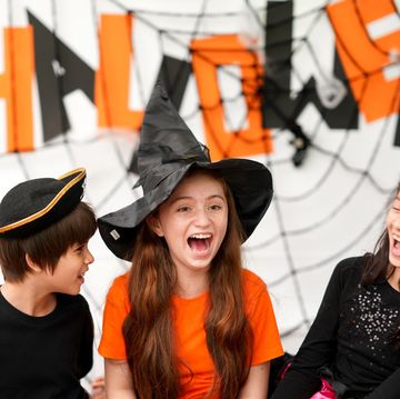 halloween riddles three kids dressed in halloween costumes and laughing