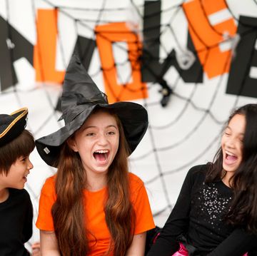halloween riddles three kids dressed in halloween costumes and laughing