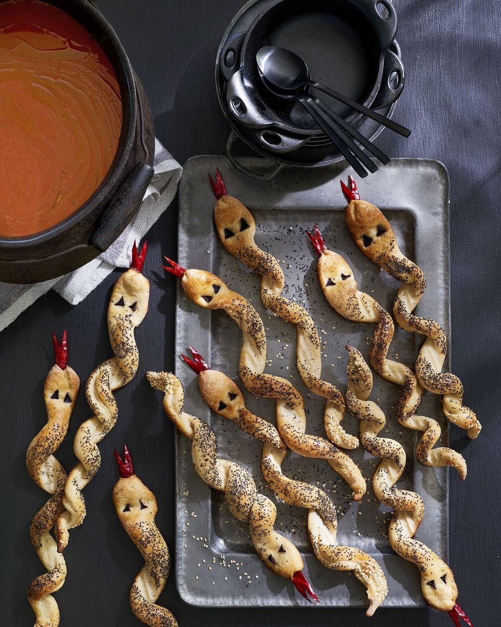breadsticks in the shape of twisted snakes with eyes and an dried chiles cut into forked tongues