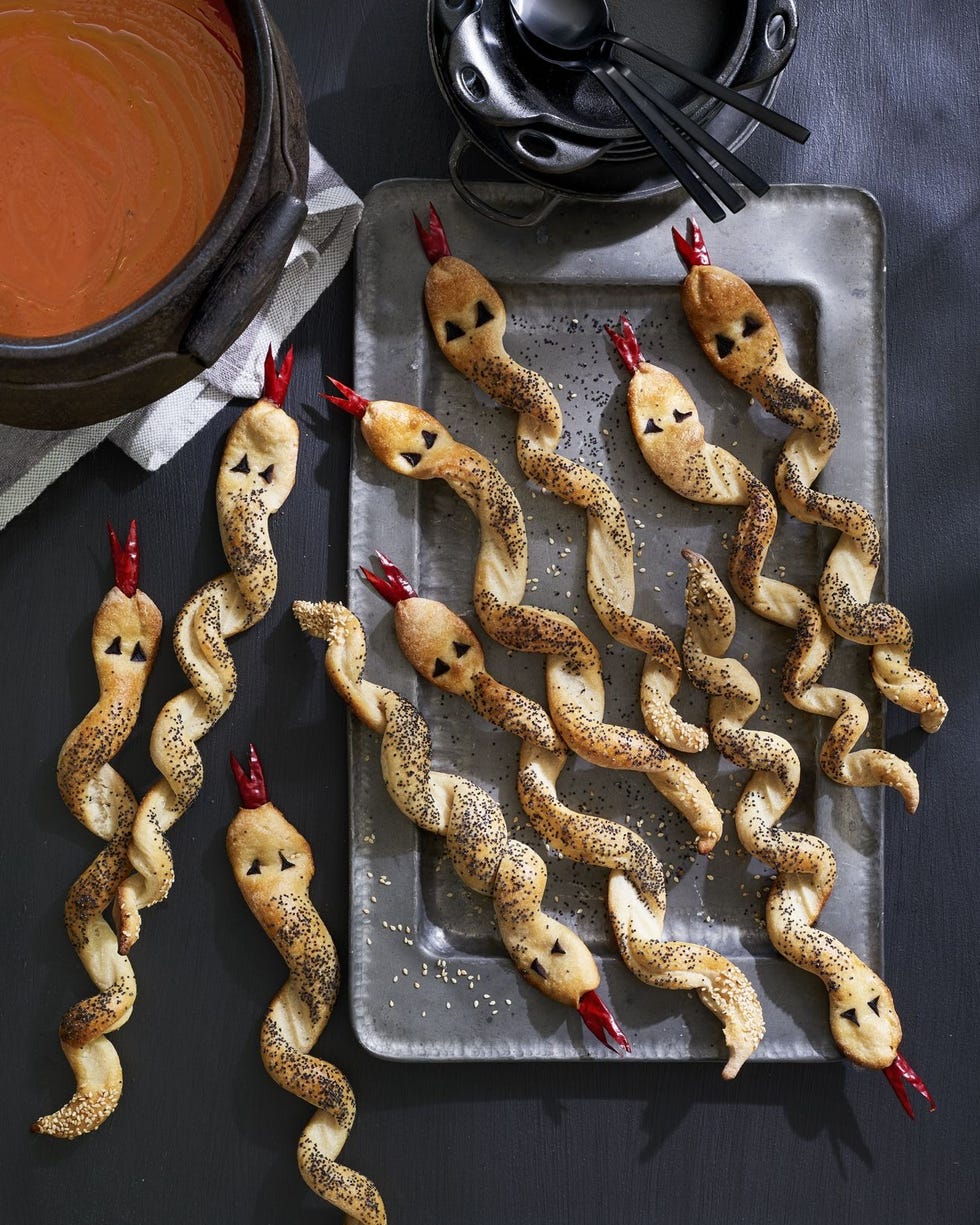 breadsticks in the shape of twisted snakes with eyes and an dried chiles cut into forked tongues