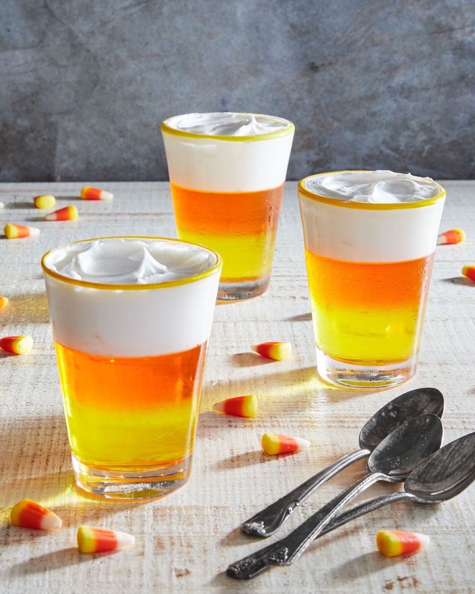 halloween candy corn gelatin cups with yellow and orange layers of jello and cool whip on top
