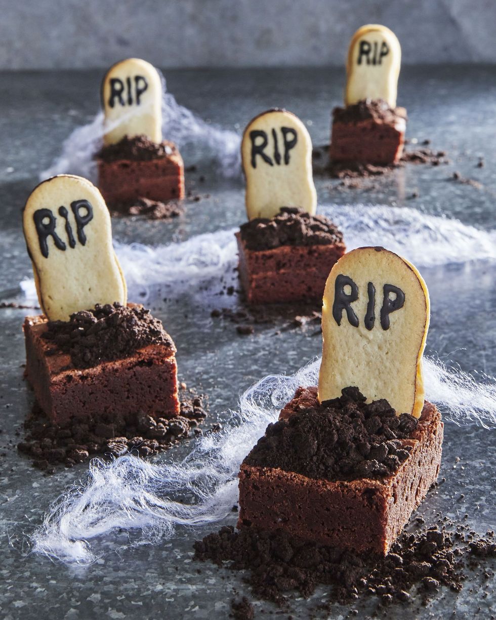 brownies decorated like graves for halloween with cookie tombstones, chocolate cookie crumble dirt