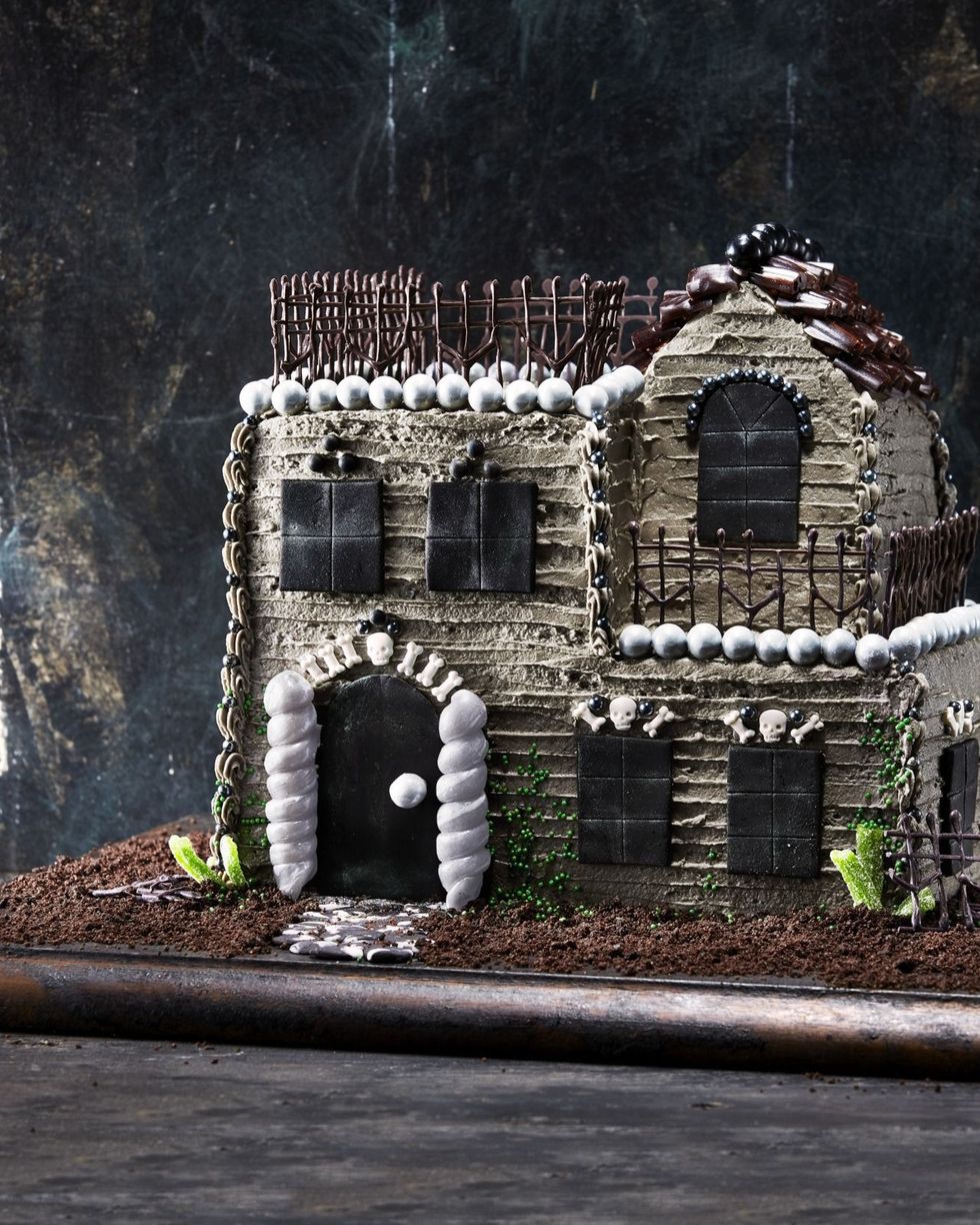 haunted house cake on a dark wooden serving board