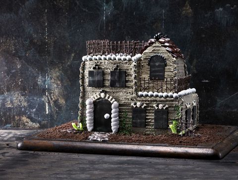 haunted house cake on a dark wooden serving board