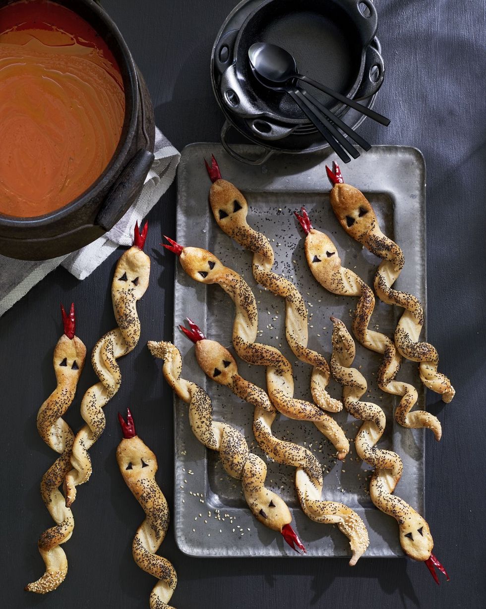 breadsticks twisted to look like snacks with eyes made of black olives and forked tongues made of dried chiles