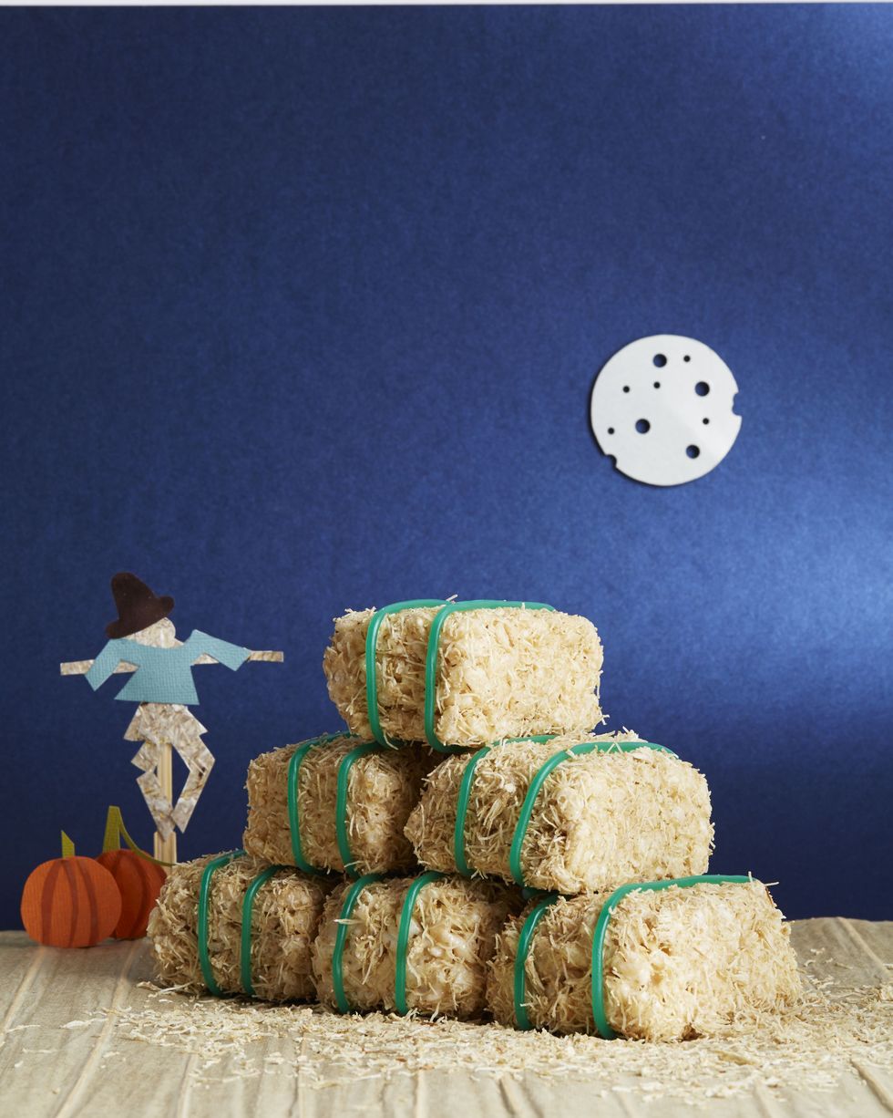 cereal bar hay bales staked on a piece of parchment with a paper scarecrow and paper pumpkins in the background