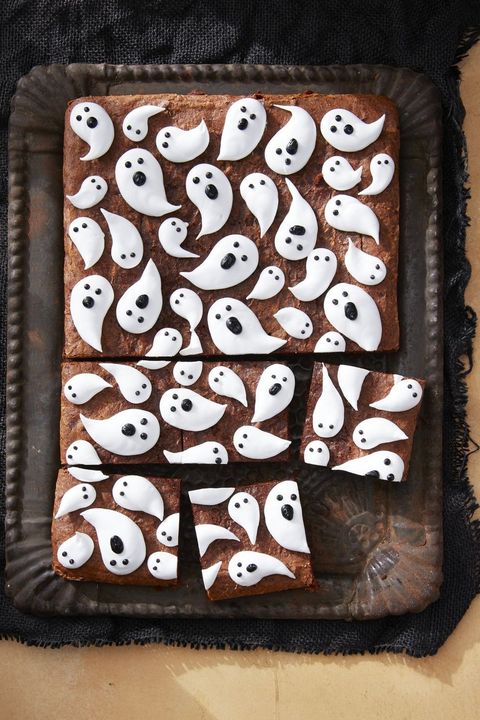 a tray of brownies with marshmallow ghosts piped on top