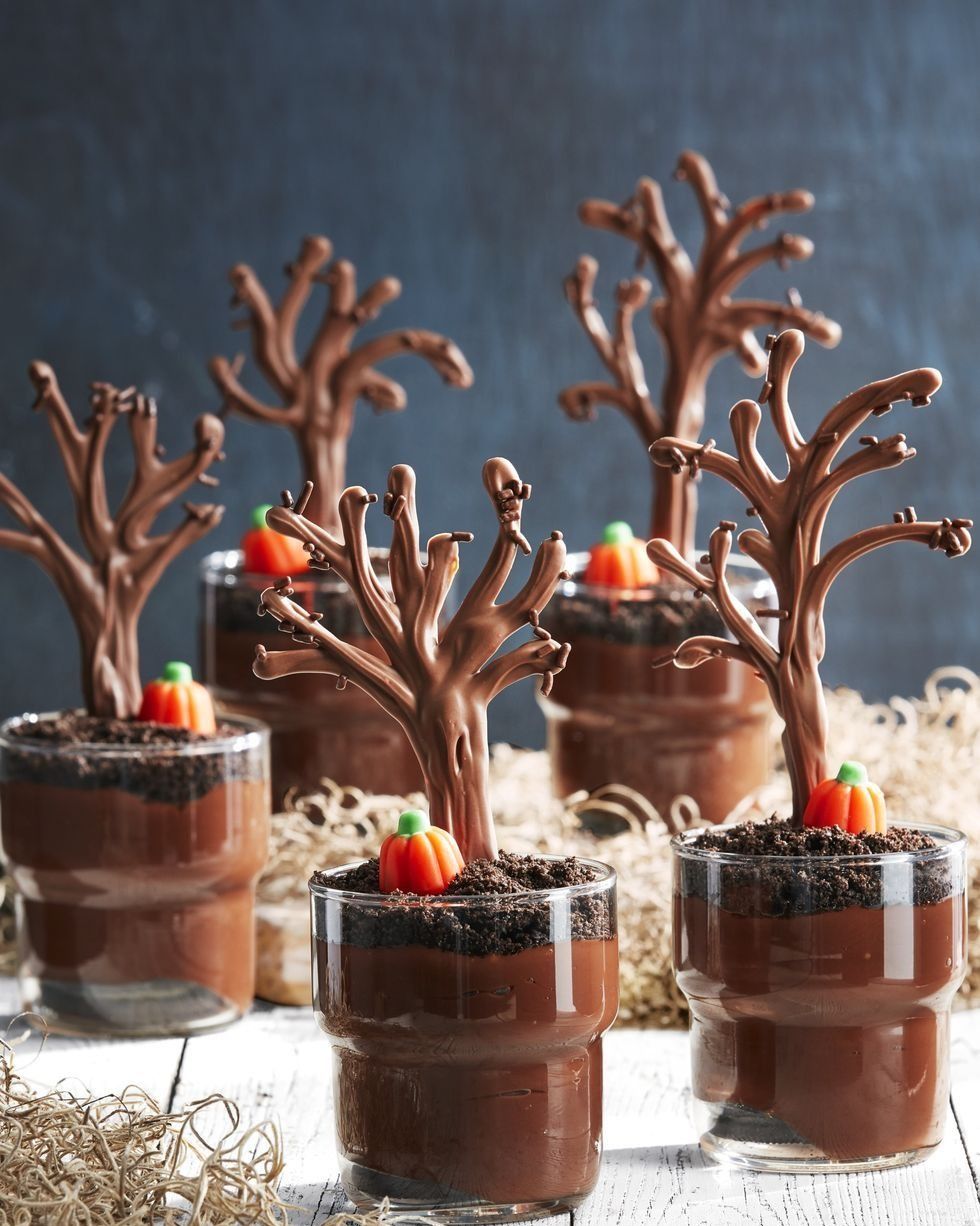 individual chocolate pudding cups with a chocolate tree and a candy pumpkin on top of each