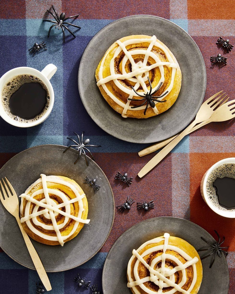 pumpkin spice buns with spider web glaze on plates with forks