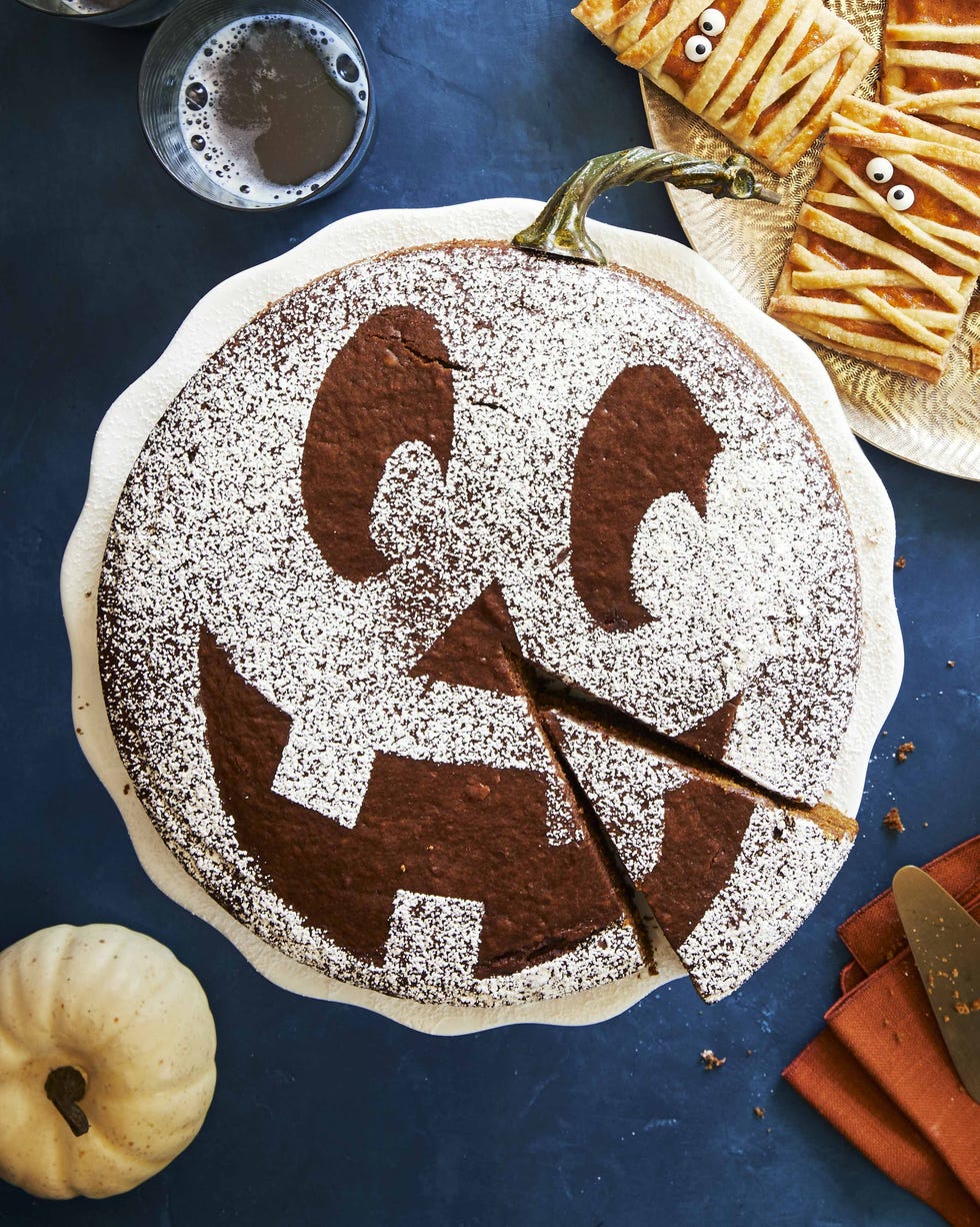 spiced pumpkin molasses cake topped with a powdered sugar jackolantern face