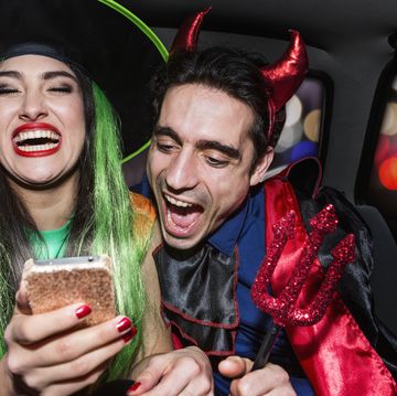halloween witch and devil laughing in back of car